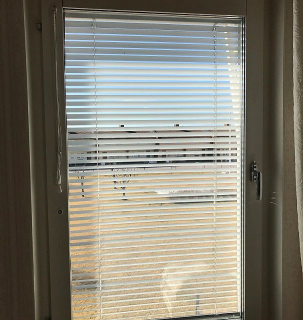 Persienn i eytt fönster som är vinklad utåt